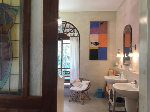 un bagno con 2 lavandini e vetrate istoriate di Son & Roberto a Karangasem