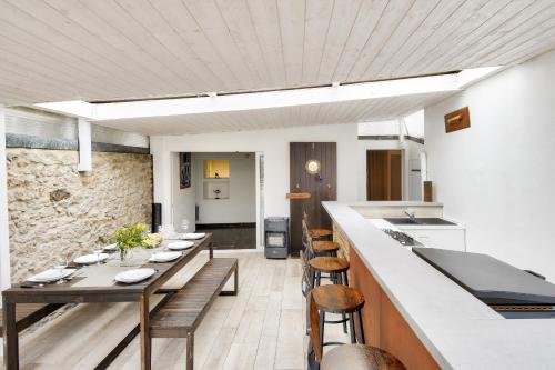 une cuisine et une salle à manger avec une table et des chaises dans l'établissement Maison avec jardin pour 8 à 550m de la plage, à Barbâtre