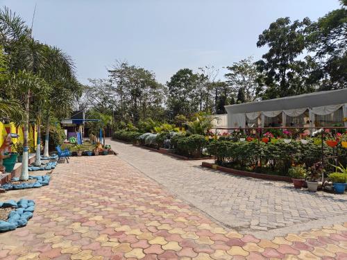 a cobblestone walkway with flowers and plants at Prashaanti Tourist lodge and Restaurant in Bongaigaon