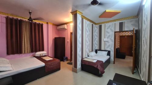 a bedroom with two beds and a mirror at Prashaanti Tourist lodge and Restaurant in Bongaigaon