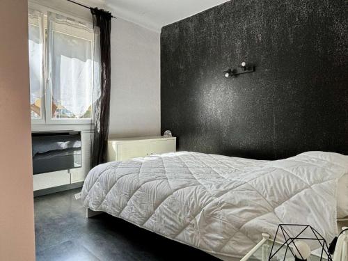 - une chambre avec un lit et un mur noir dans l'établissement Appartement 2 pièces 4 couchages ARGELES SUR MER AR910-016, à Argelès-sur-Mer