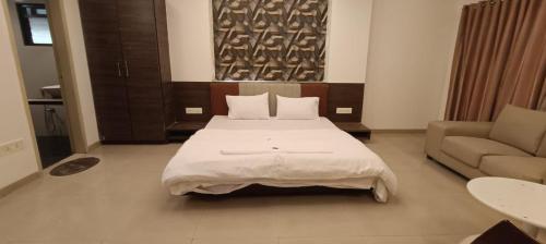 a bedroom with a large bed and a couch at hotel nova haven in Ankleshwar