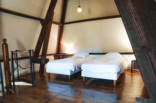 deux lits dans une chambre avec des draps blancs dans l'établissement Belle maison avec piscine chauffée pour 6, à Saint-Léon-sur-Vézère