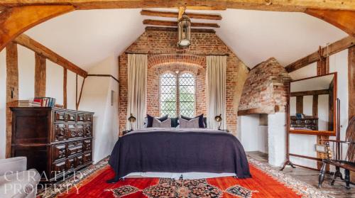 a bedroom with a bed and a large window at A Luxury Tudor Hall & Gardens Located on Breath-Taking Norfolk Estate in Norwich
