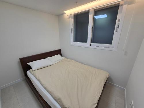 a small bedroom with a bed and a window at Siaring2room in Seoul