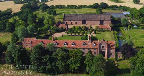 an aerial view of a large house with a yard at A Luxury Tudor Hall & Gardens Located on Breath-Taking Norfolk Estate in Norwich