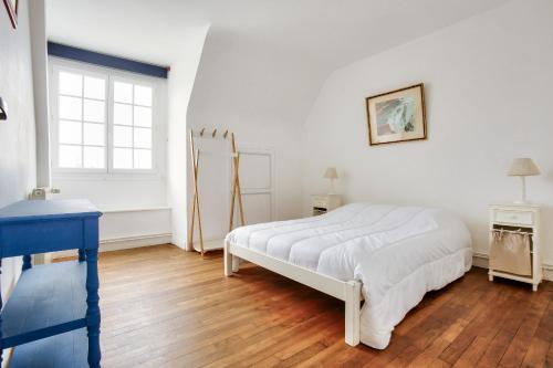 une chambre blanche avec un lit et une fenêtre dans l'établissement Appartement pour 6 en plein centre de Dinard, à Dinard