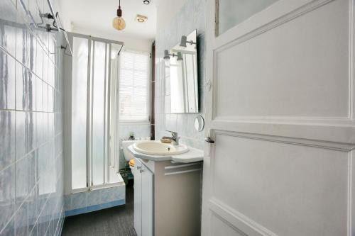 une salle de bain blanche avec un lavabo et une fenêtre dans l'établissement Appartement pour 6 en plein centre de Dinard, à Dinard
