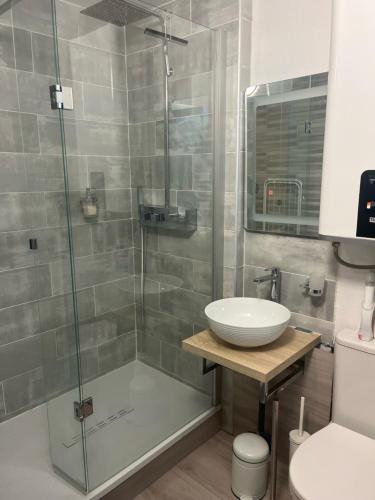 une salle de bain avec une douche en verre avec un lavabo dans l'établissement Cabourg plage 2 pieces, à Cabourg