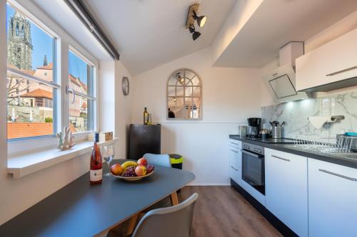 a kitchen with a table with a bowl of fruit on it at Daniels Apartment an der Schloßbrücke in Meißen