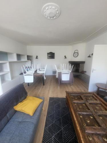 un salon avec un canapé, une table et des chaises dans l'établissement La maison de Marie, à La Boissière-sur-Evre