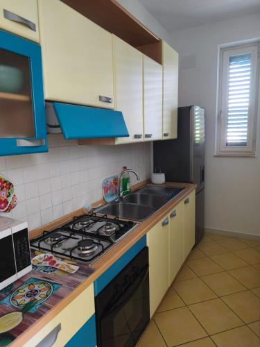 a kitchen with a sink and a stove top oven at Villetta vicino al mare in Marina di Mancaversa