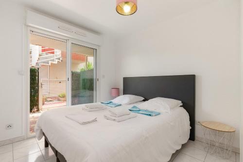 a bedroom with a large white bed with towels on it at REVE DE MER Duplex 6 pers en bord de plage in Frontignan
