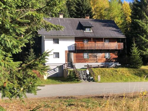 a large white house with a balcony on the side of it at Nockstern Hütte in Ebene Reichenau