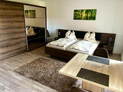 a room with two beds and a table and a mirror at Gut Rottmannshagen Mecklenburgische Seenplatte in Jürgenstorf