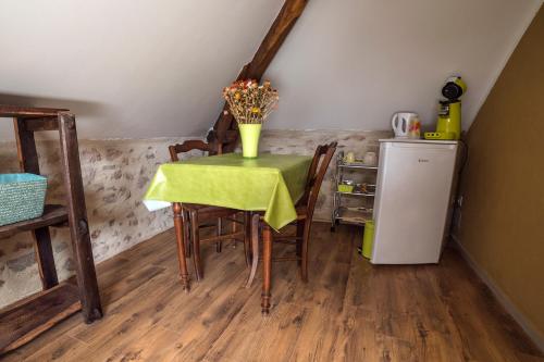 a dining room with a table and a refrigerator at Ecuries de Saint Maurice- Maison d'hôtes de Gondou in Lacapelle-Marival