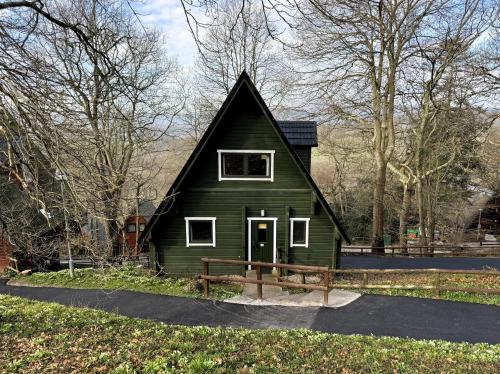 a green house with a black roof at Tor View Lodge with Hot Tub & Sauna - Spa Resort - South Devon in Chudleigh Knighton