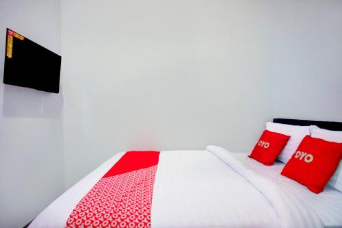 a bedroom with a bed with red pillows at Hotel O Krakatau Near Universitas Muhammadiya Sumatra Utara UMSU in Medan