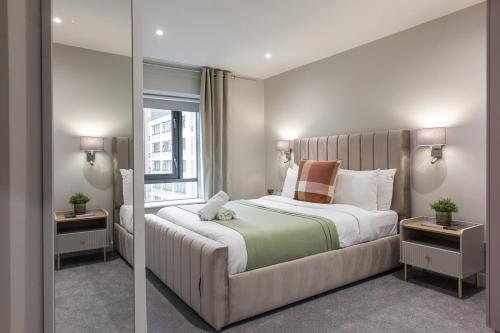 a bedroom with a large bed and a window at Stylish, Luxury, Parking Sleeps 6, 2-Bath, City Centre in Belfast