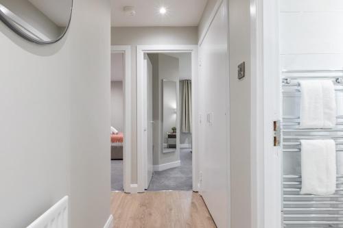 a hallway with white walls and white towels at Stylish, Luxury, Parking Sleeps 6, 2-Bath, City Centre in Belfast