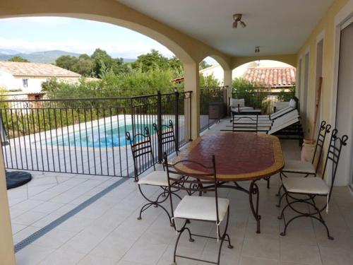 un patio avec une table et des chaises et une piscine dans l'établissement Villa CORSE, à Solaro