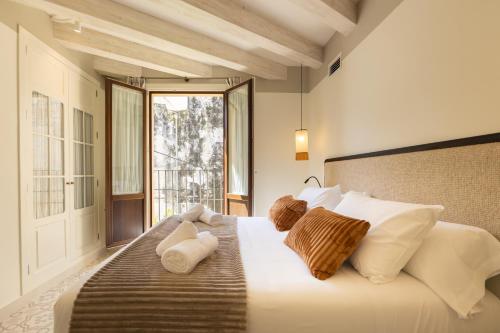 a bedroom with a bed with white pillows and a window at Aladro Apartamentos by Valcambre in Jerez de la Frontera