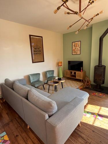 un salon avec un canapé et une télévision dans l'établissement Le moulin d'Artus, à Beaubery