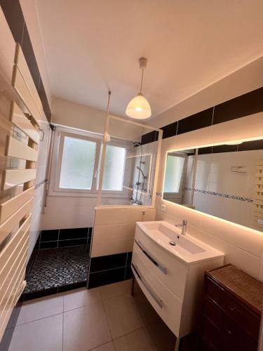 La salle de bains est pourvue d'un lavabo blanc et d'une baignoire. dans l'établissement Appartement 6 personnes, à Saint-Raphaël