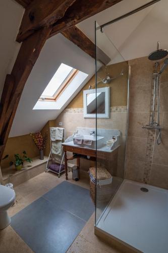 a bathroom with a glass shower and a sink at Ecuries de Saint Maurice- Maison d'hôtes de Gondou in Lacapelle-Marival