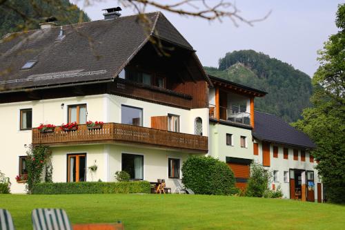 トラウンキルヒェンにあるSuite am Attwengerhofの黒い屋根の大きな白い家