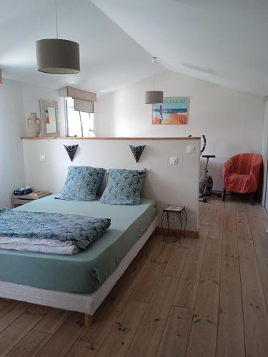 une chambre avec un lit avec des oreillers bleus dans l'établissement maison avec piscine bord de mer, à Longeville-sur-Mer
