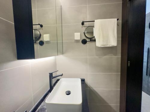 Un baño con un lavabo blanco y un espejo. en M resident, en Phnom Penh