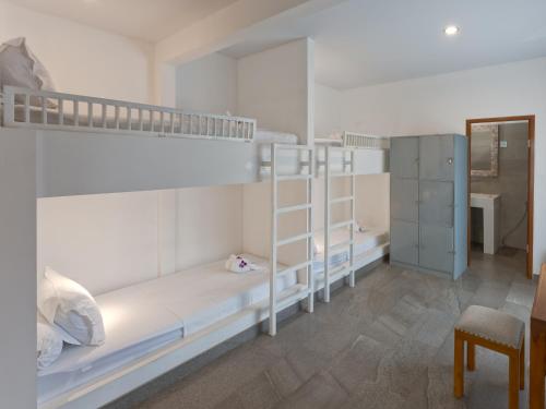 a bedroom with two bunk beds and a desk at Bubu Homestay Tulamben in Tulamben