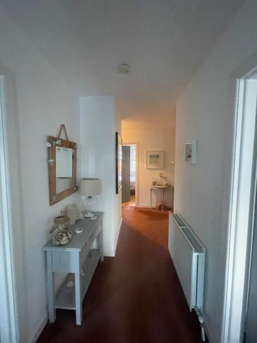 a white room with a table and a mirror at Portballintrae 3 bedroom cosy coastal bungalow in Portballintrae