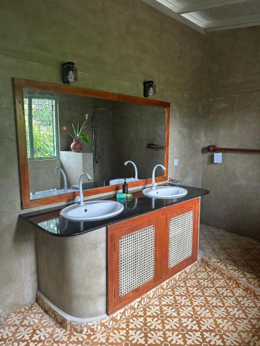 a bathroom with two sinks and a mirror at Isolabella Ayurveda Hotel Hiriketiya in Nilwella