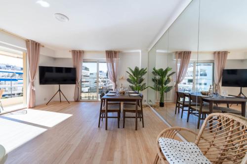 d'un salon avec des tables, des chaises et une télévision à écran plat. dans l'établissement Spacious 2-Br Apartment Walk to Beach & City Center, à Cannes