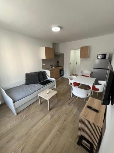 a living room with a couch and a table at Les balcons du 115 BIS - Appartement standing in La Bourboule