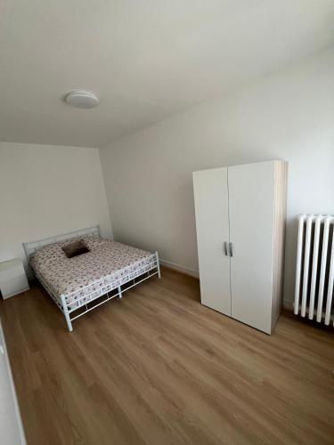 a bedroom with a bed and a white cabinet at Les balcons du 115 BIS - Appartement standing in La Bourboule