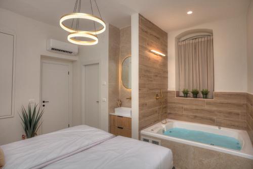 a bathroom with a tub and a bed in it at כתר הסמטה in Safed