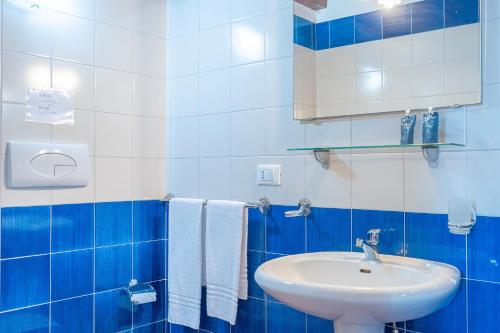 a blue and white bathroom with a sink and towels at Al Palmento Relais in Siracusa