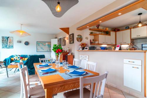 une cuisine et une salle à manger avec une table et des chaises en bois dans l'établissement Ty Kéréré - Calme, Grand Jardin Arboré, 500m plage, à Locmariaquer