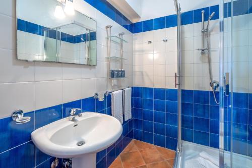 a blue and white bathroom with a sink and a shower at Al Palmento Relais in Siracusa