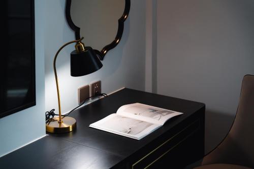 a desk with a lamp and a book on it at Cloud 22Land hotel in Hanoi