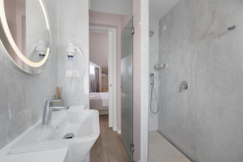 a white bathroom with a sink and a shower at Villa Primordia in Podgora