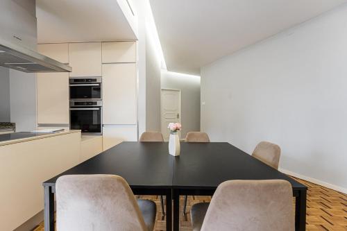 a dining room with a black table and chairs at GuestReady - Charming City Escape in Braga