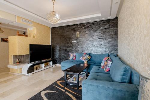 a living room with a blue couch and a brick wall at Comfort Stay by Mohammed V Airport in Nouaseur