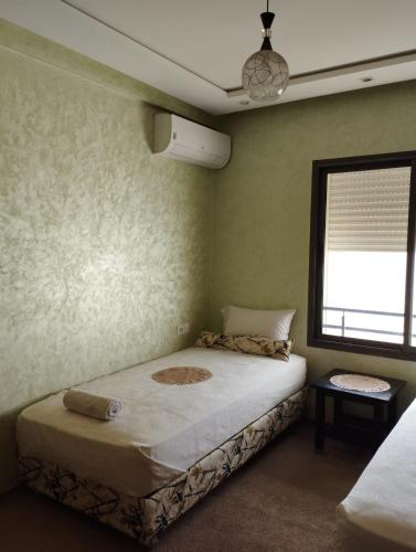 a bedroom with a bed in a room with a window at Comfort Stay by Mohammed V Airport in Nouaseur