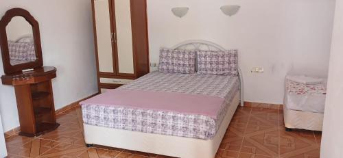a bedroom with a bed and a dresser in it at Selin Pansiyon in Kemer
