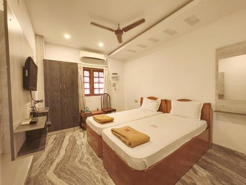a bedroom with a large bed and a window at Hare Rama Hare Krishna - EESHA Hotel in Rāmeswaram