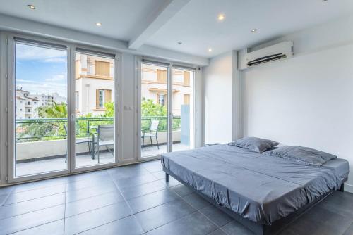 a bedroom with a bed and a balcony at Studio Juan les pins avec terrasse in Juan-les-Pins
